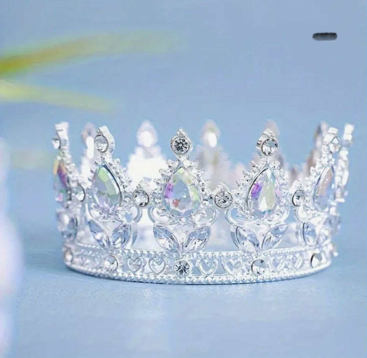 Corona de metal plateado con piedras.